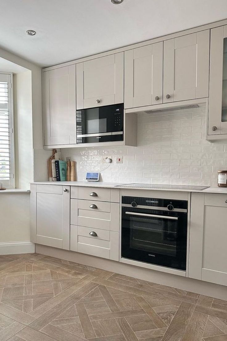 a kitchen with white cabinets and an oven