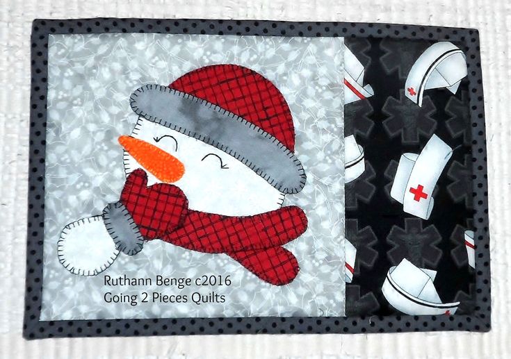 a quilted snowman with a red hat and scarf