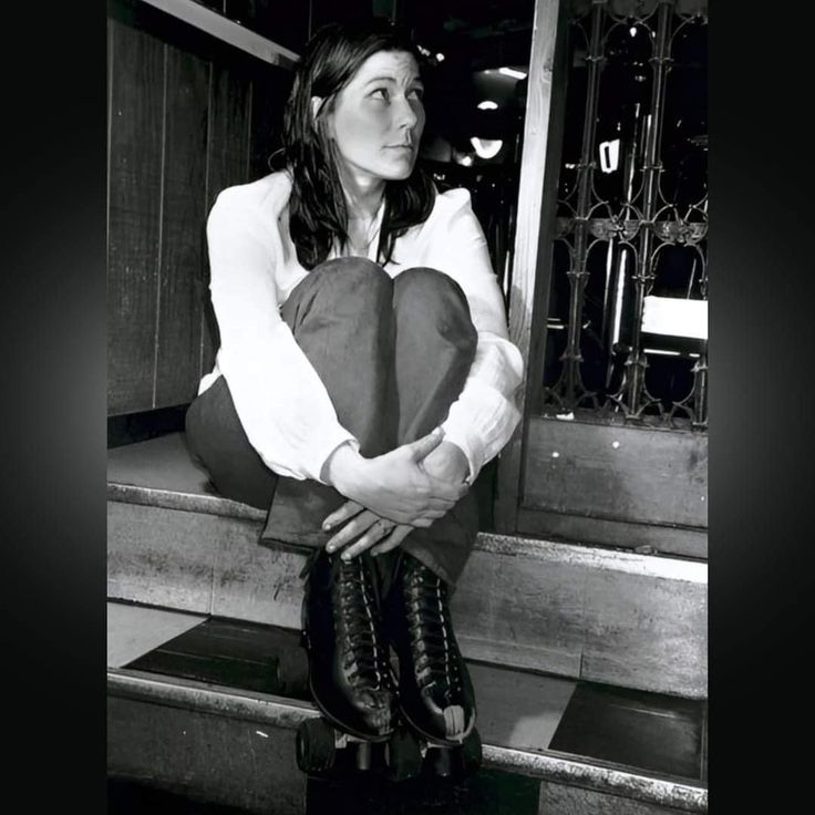 black and white photograph of a woman sitting on steps holding a heart - shaped pillow