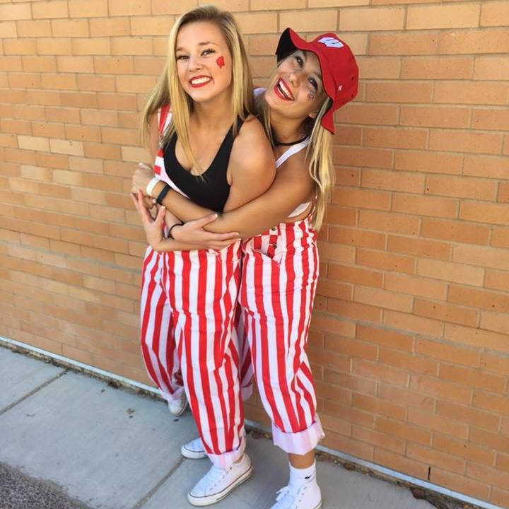 two girls dressed in red and white striped pants, one with her arms around the other