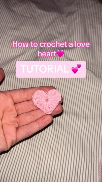 someone is holding a small pink heart in their hand with the text how to crochet a love heart