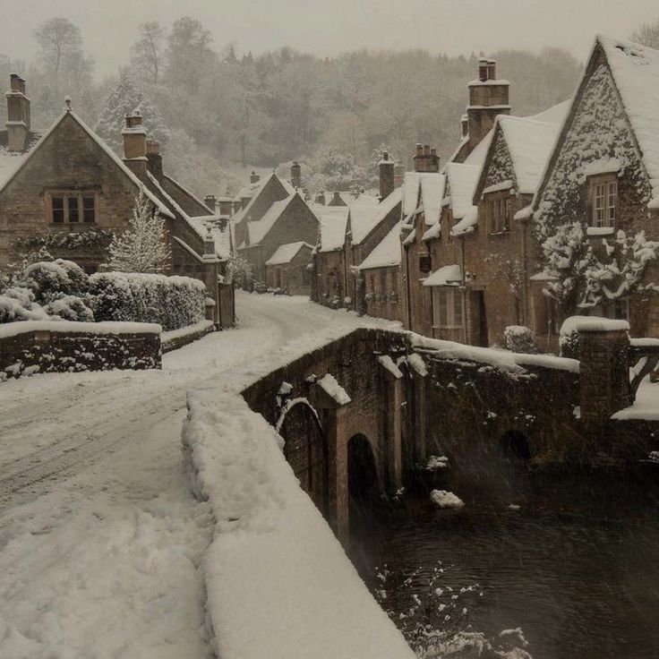 a snow covered street with houses and water