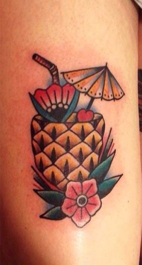 this is a pineapple tattoo with an umbrella and flowers on the side of it