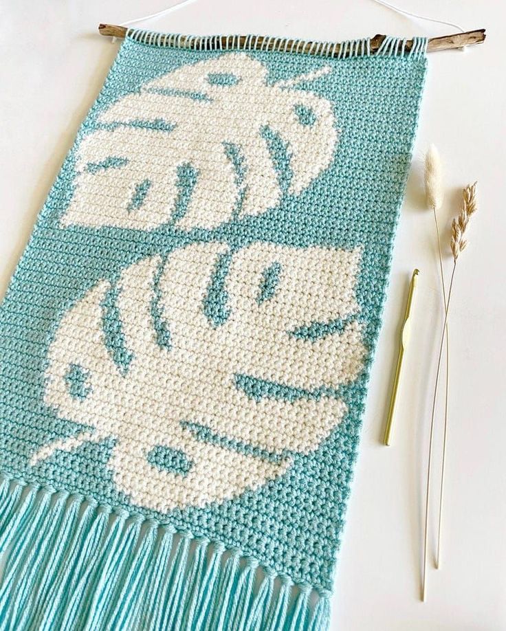 a crocheted table runner next to some knitting needles