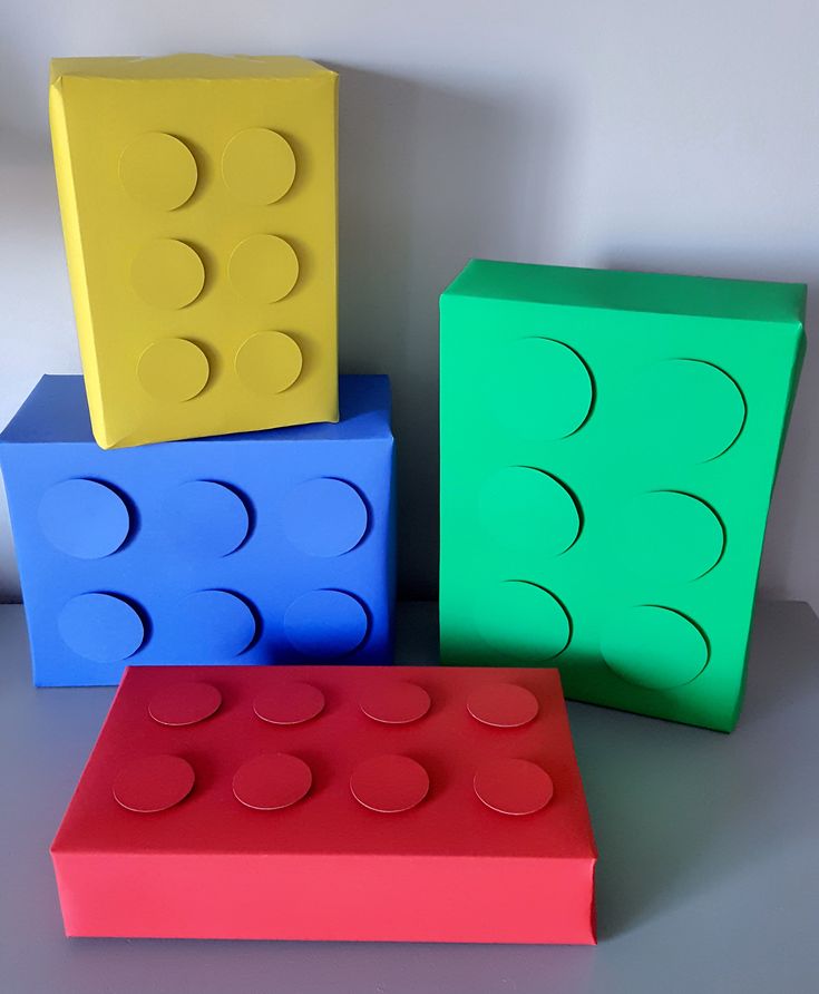 three lego blocks sitting next to each other on top of a white surface with circles painted on them