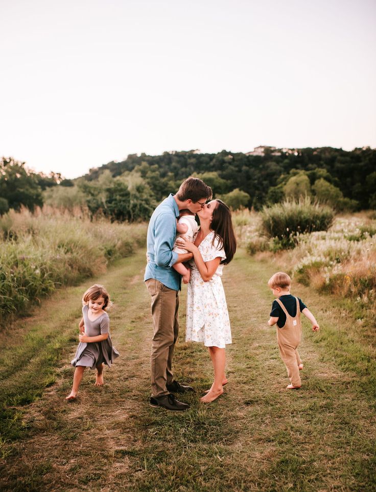 a man and woman kissing while two small children look on