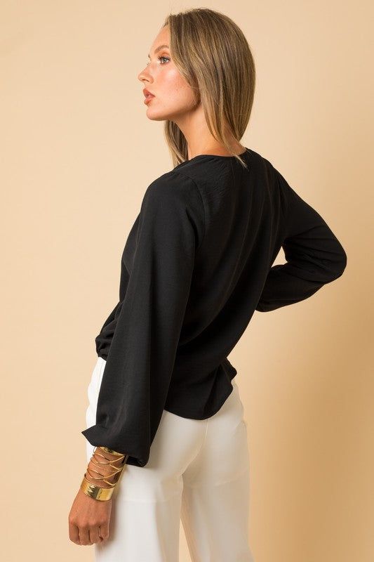 The Surplice Shoulder Shirring Top effortlessly combines sophistication with a touch of allure. With its surplice neckline and artful shoulder shirring, this top offers a flattering and stylish silhouette. SPECIFICATIONS: The model is wearing a small Model Specs Height: 5'10" Bust: 33B Waist: 23.5" Hips: 35" Style: Casual Print / Pattern: Solid Silhouette: Top Fit: Regular Embellishment: Elastic Cuff Neck Line: Surplice Sleeve: Long Sleeve Length: Hip Length Closure: Pullover Lining: No Made In: Shirring Top, Surplice Top, Balloon Sleeve Top, Flattering Tops, Surplice Neckline, Flowy Blouse, Top Model, Print Pattern, Hip Length