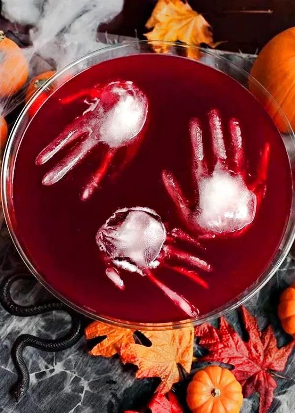 a glass bowl filled with liquid and two handprints on top of it, surrounded by fall leaves