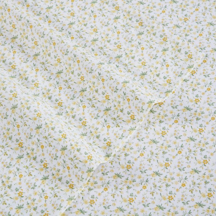 a white shirt with yellow and green flowers on it