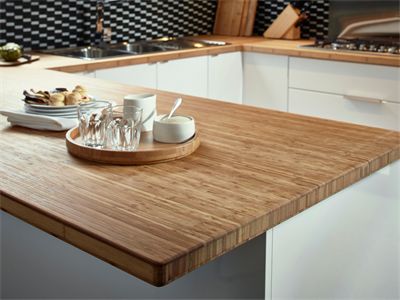 a wooden counter top in a kitchen with white cabinets