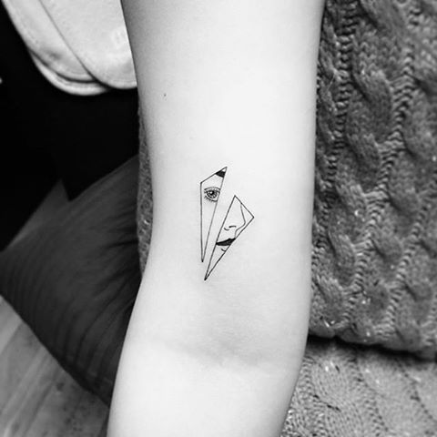 a black and white photo of a small tattoo on the left inner arm, with an origami in it