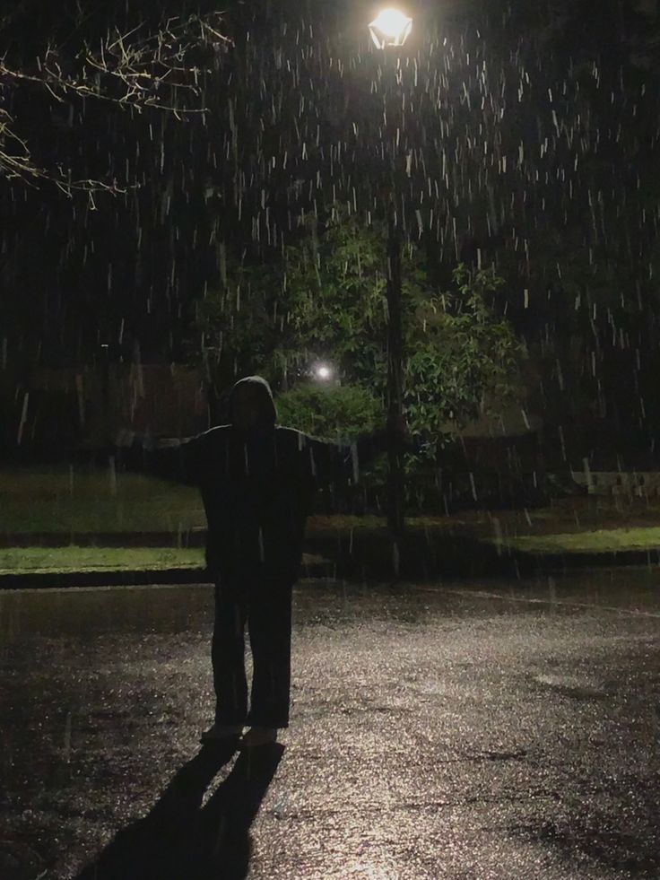 a person standing in the rain at night