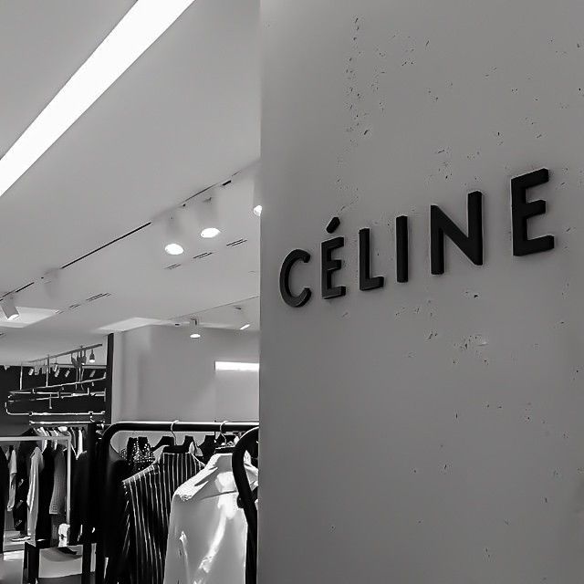 black and white photo of clothes on racks in a clothing store with the name celine