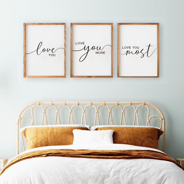 a bed with two framed pictures above it and the words love you most on them