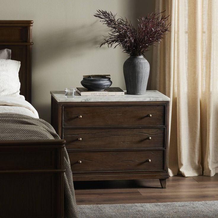 a bedroom scene with focus on the bed and nightstands, along with a plant