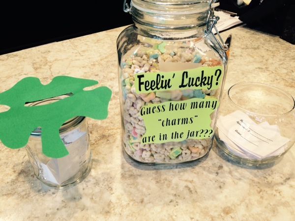 a jar filled with lots of candy next to a cut out of a green frog