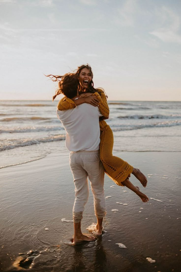 a man carrying a woman on his back at the beach