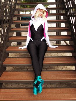 a woman sitting on top of some steps wearing a cat suit and blue bow tie