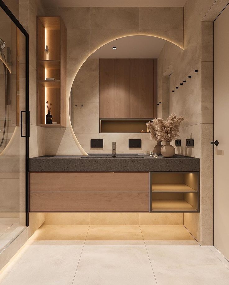 a modern bathroom with an oval mirror above the sink and marble countertop, lighted by recessed lighting