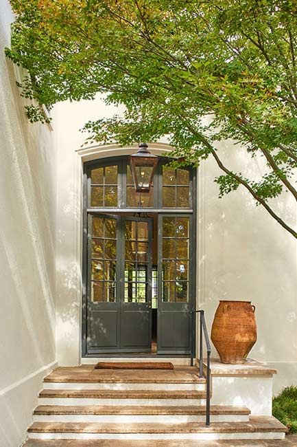 an entrance to a home with steps leading up to it and a vase on the side