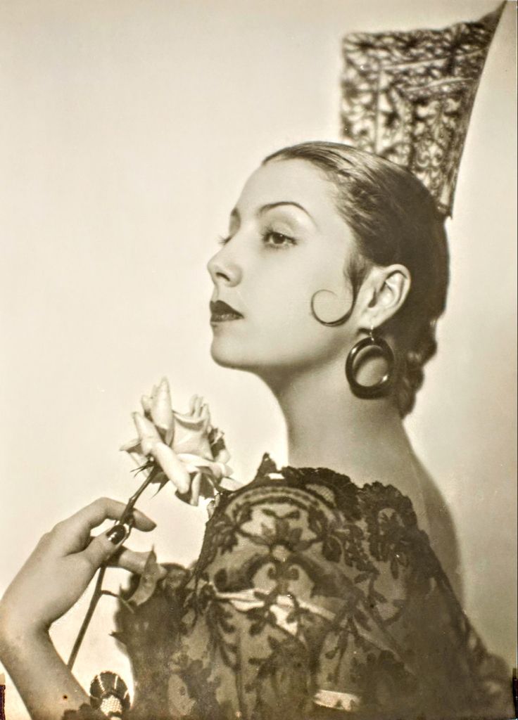 an old photo of a woman with a rose in her hand and a crown on her head