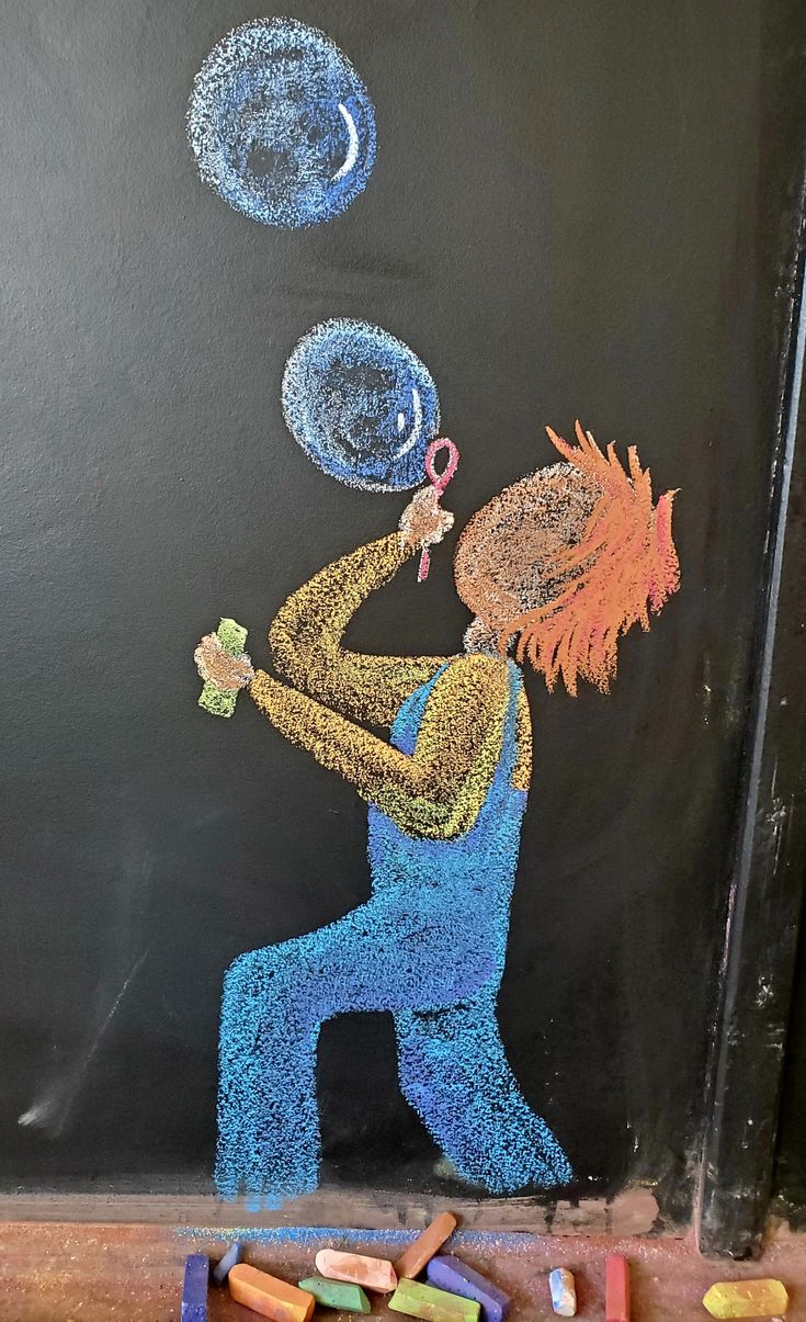 a chalk drawing of a boy holding a tennis racket and ball in his hand