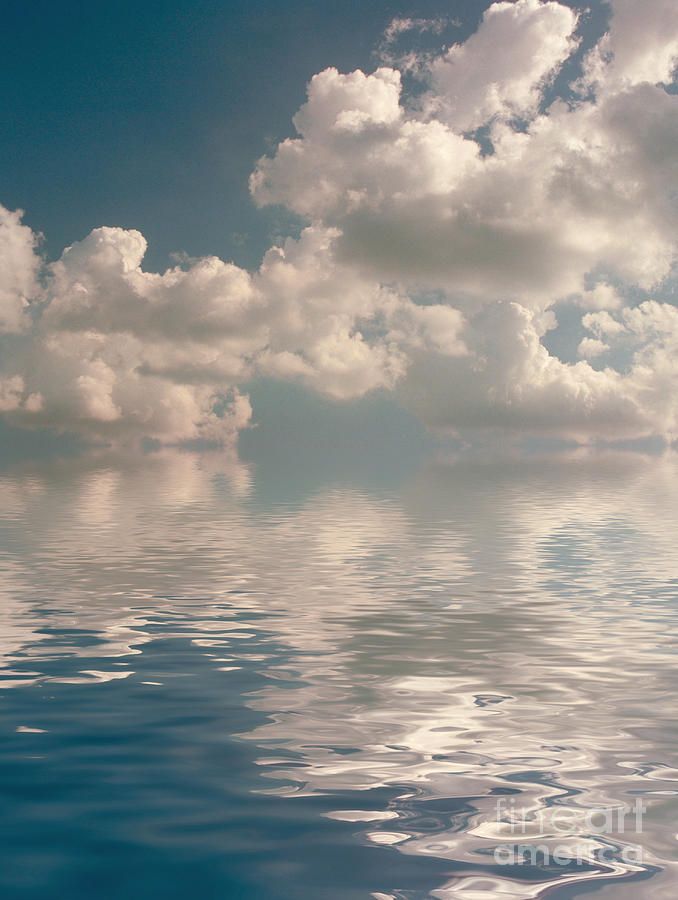 the sky is filled with clouds and reflecting on the water's surface as if it were floating in the ocean