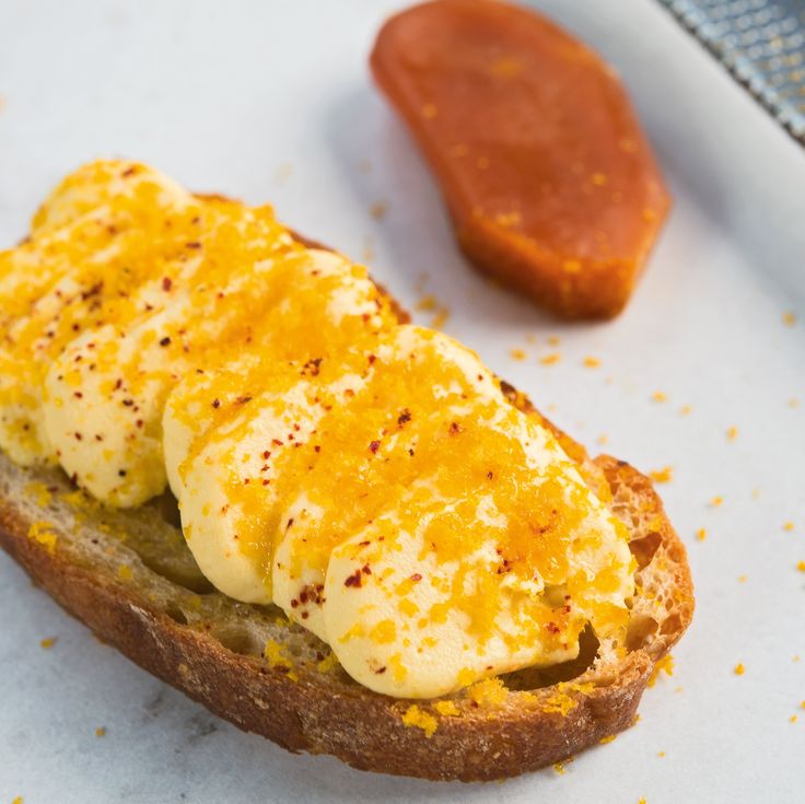 a toasted sandwich with eggs on it next to a hot dog bun covered in cheese