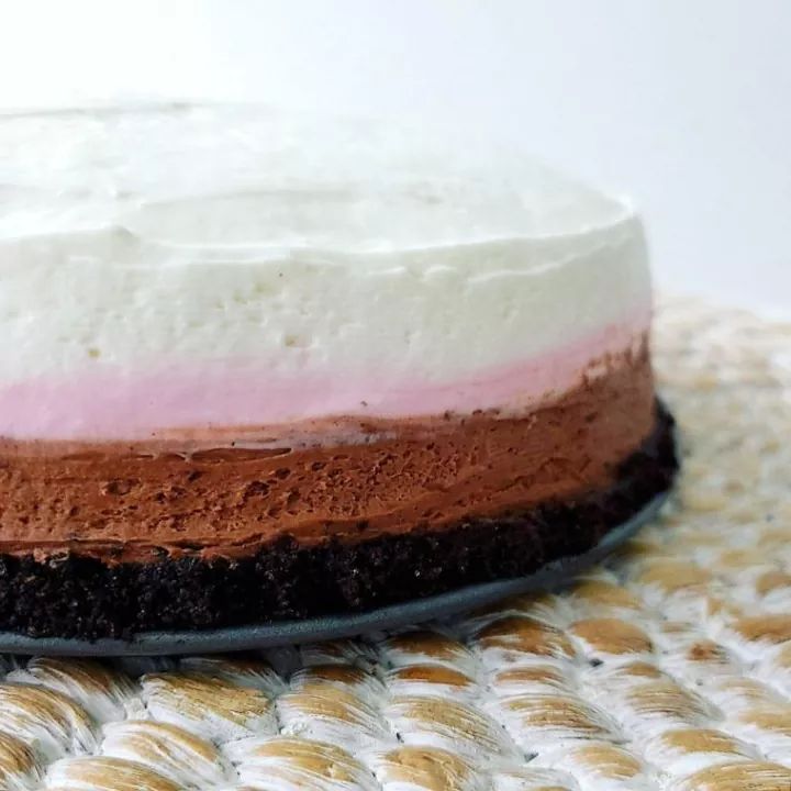 a close up of a cake with white and pink frosting on it's top