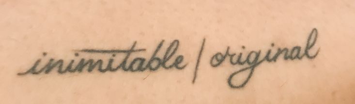 a tattoo with the words unimitable and original written on it