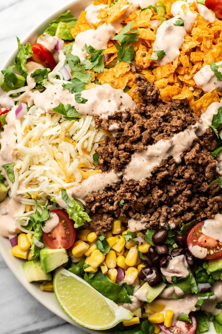 mexican salad with ground beef, corn, lettuce, tomatoes, black beans and sour cream dressing