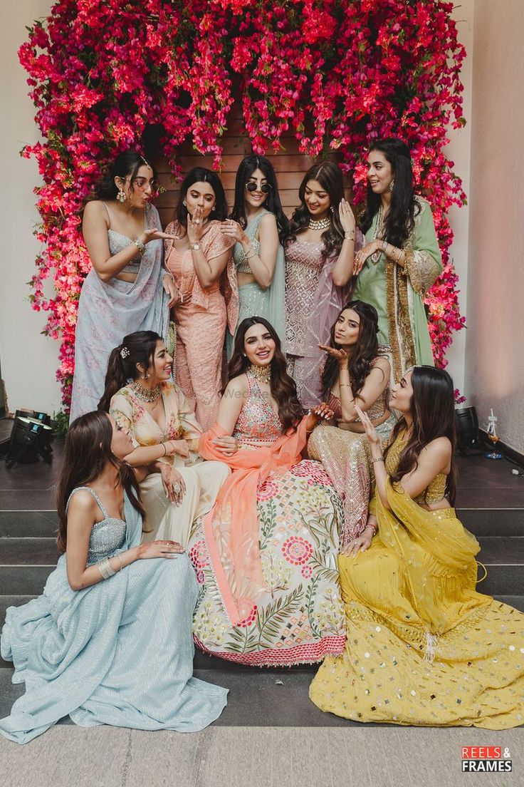 a group of women posing for a photo in front of flowers