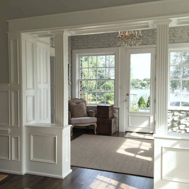 a living room with white walls and wood flooring next to two doors that lead into another room