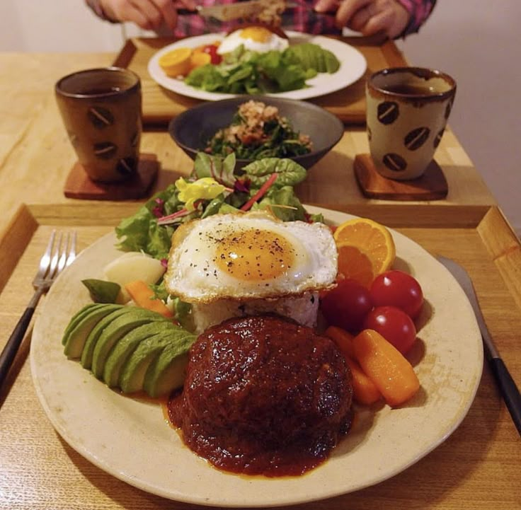 a person sitting at a table with plates of food