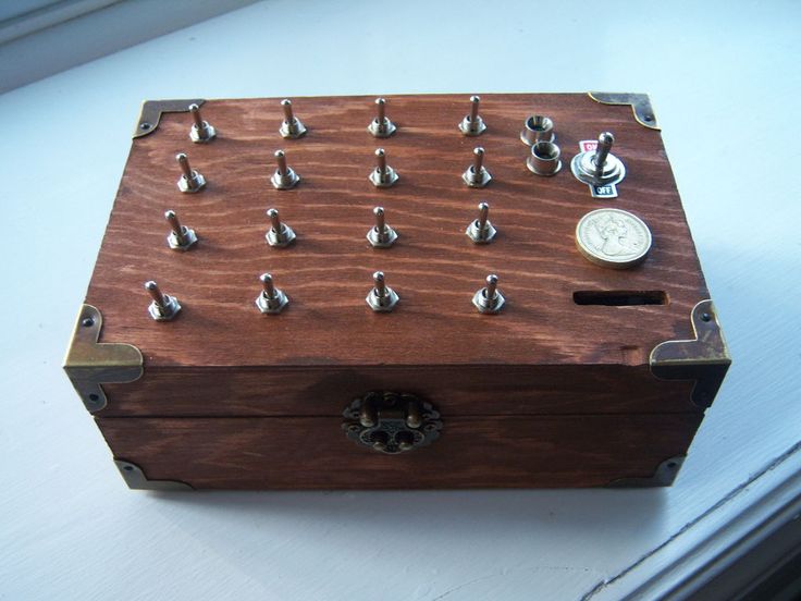 a wooden box filled with lots of silverware and knobs on top of a table