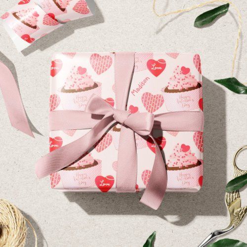 pink wrapping paper with hearts and cupcakes on it next to twine of twine