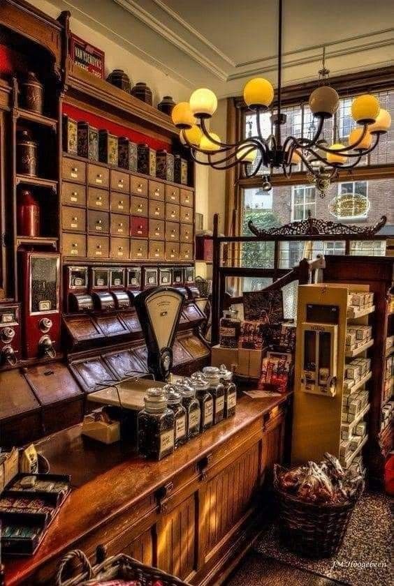 an old fashioned store with lots of items on the counter and in front of it