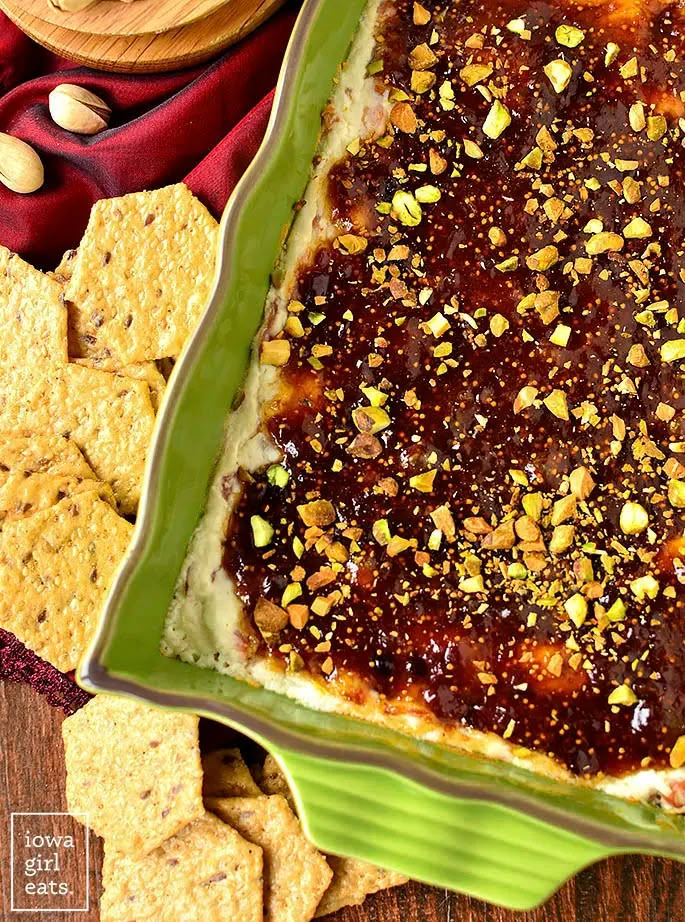 a green dish filled with food next to crackers