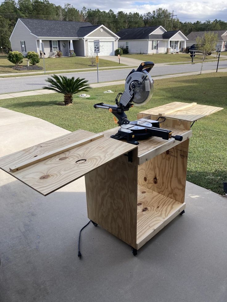 a table sawing on top of a piece of wood in front of a house