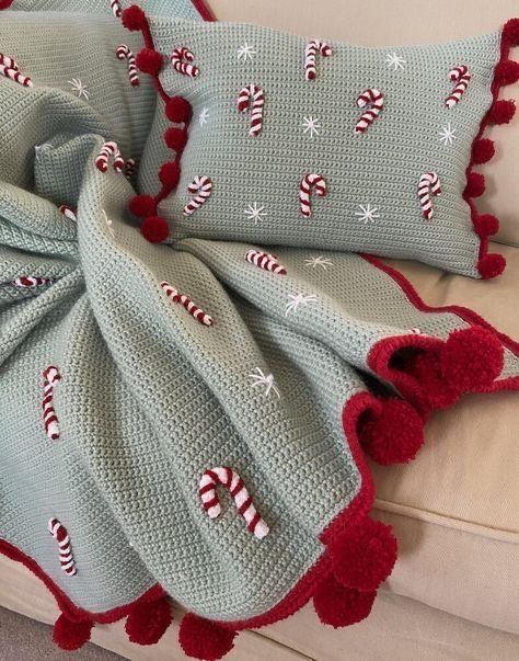 a crocheted blanket with candy canes on it is sitting on a couch