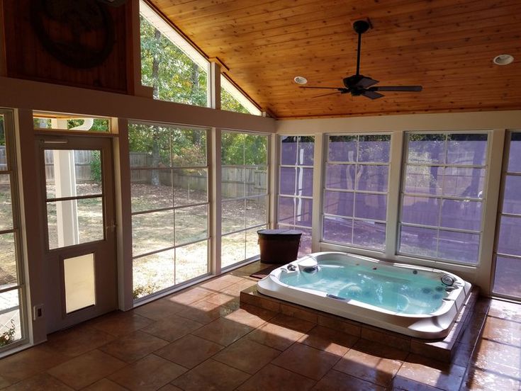 an indoor jacuzzi tub in the middle of a room with windows on both sides