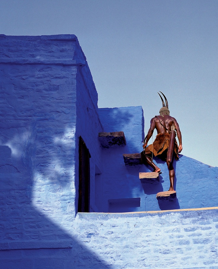 a man standing on top of a blue building