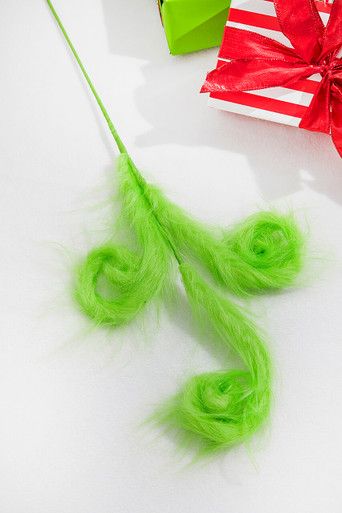 green hair is tied to a string with a red bow on it and two gift boxes in the background