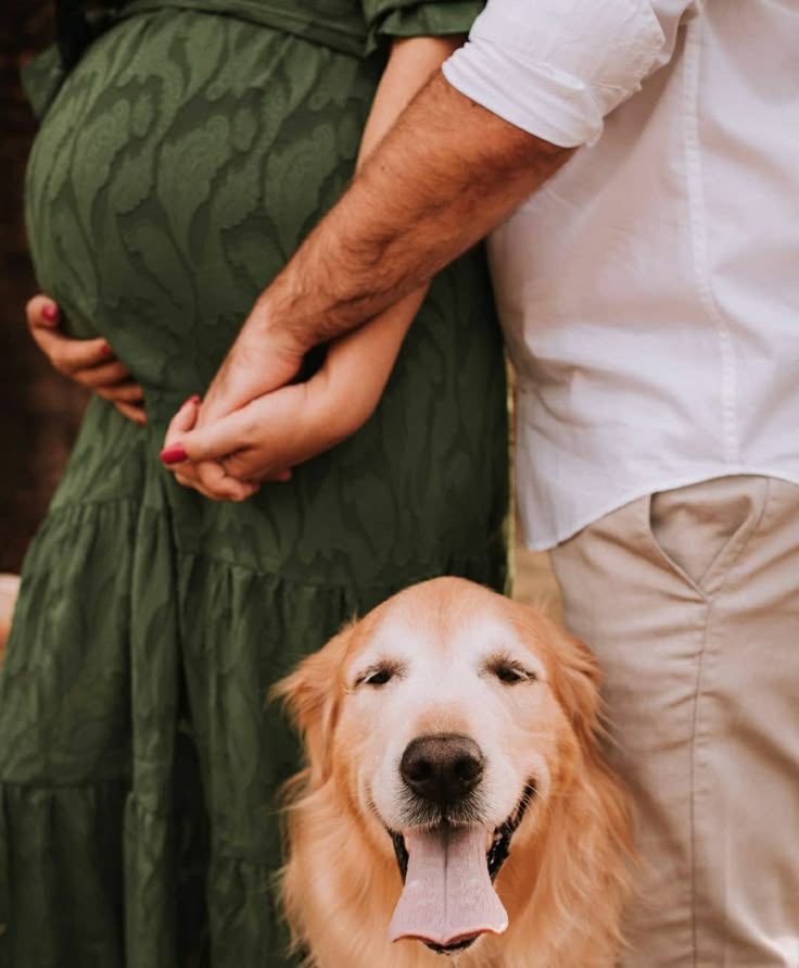 a man and woman standing next to a dog