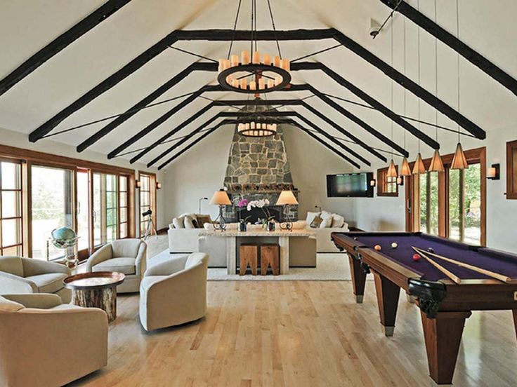 a living room with a pool table, couches and chairs in it's center