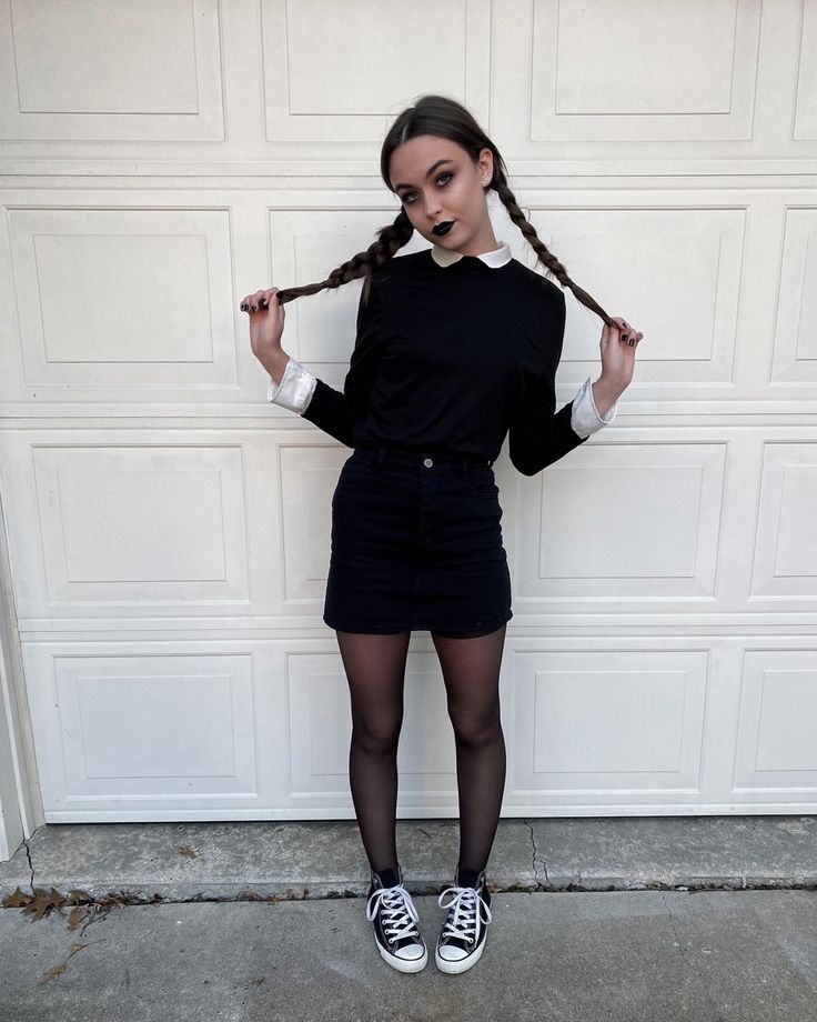 a woman with long hair standing in front of a garage door wearing black tights