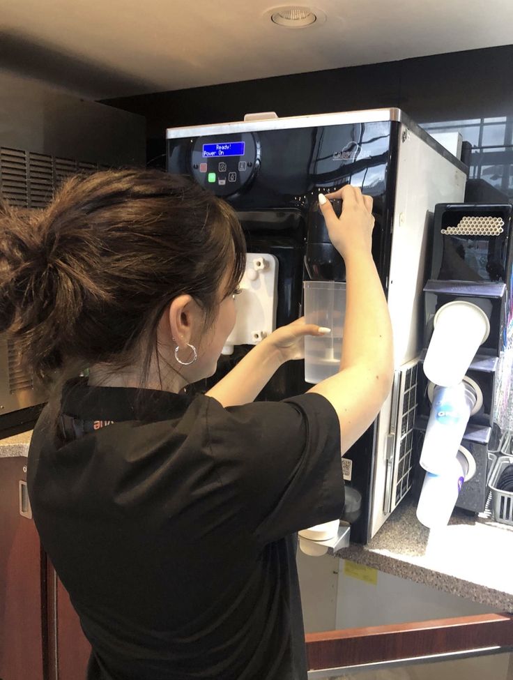 a woman is looking into an appliance that has been opened for the customers to use