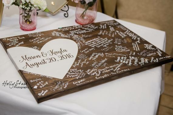 a table with two vases filled with flowers on top of it and a sign that says happy anniversary