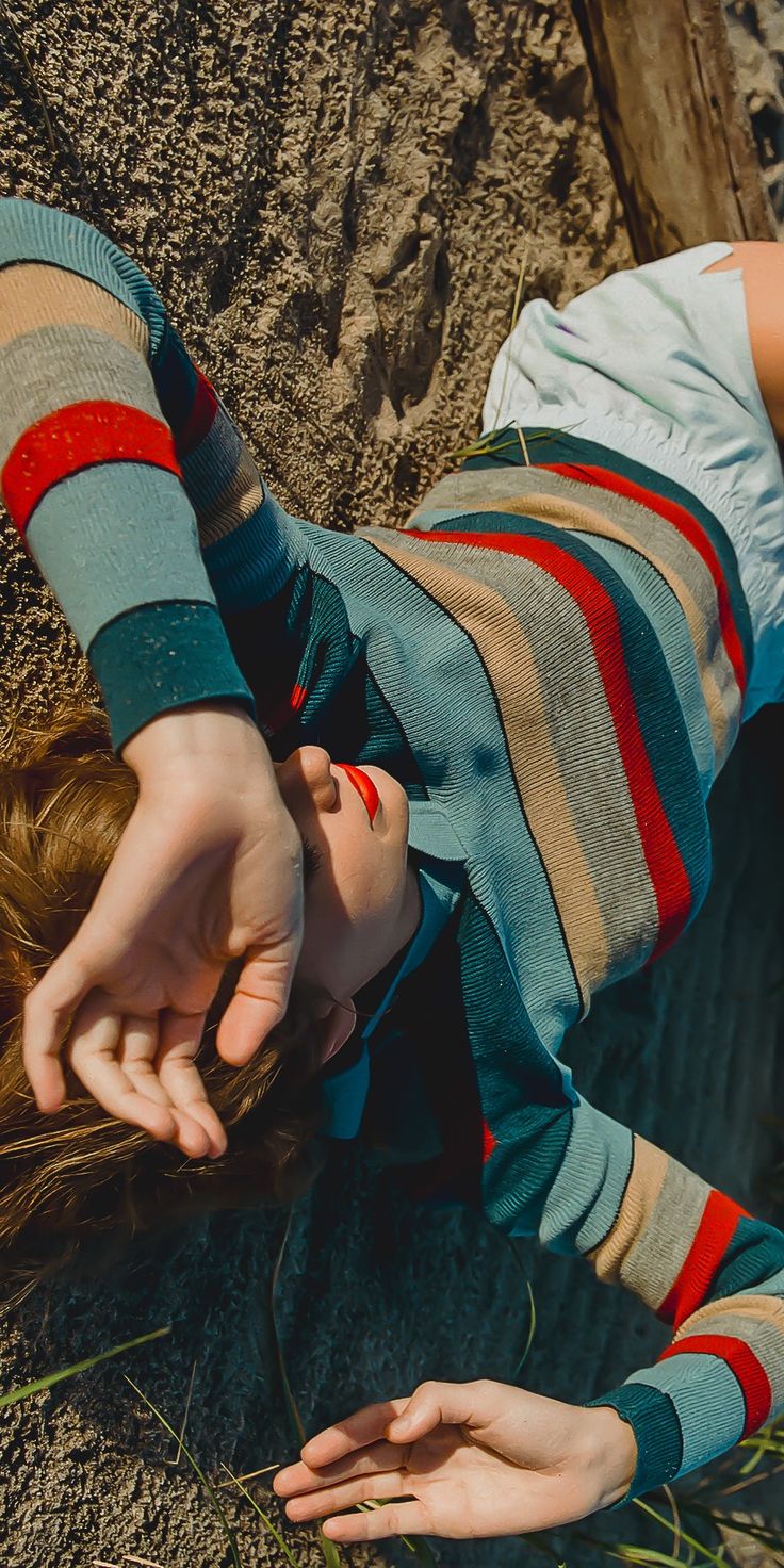 a person laying on the ground with their hands in the air and one hand reaching for something