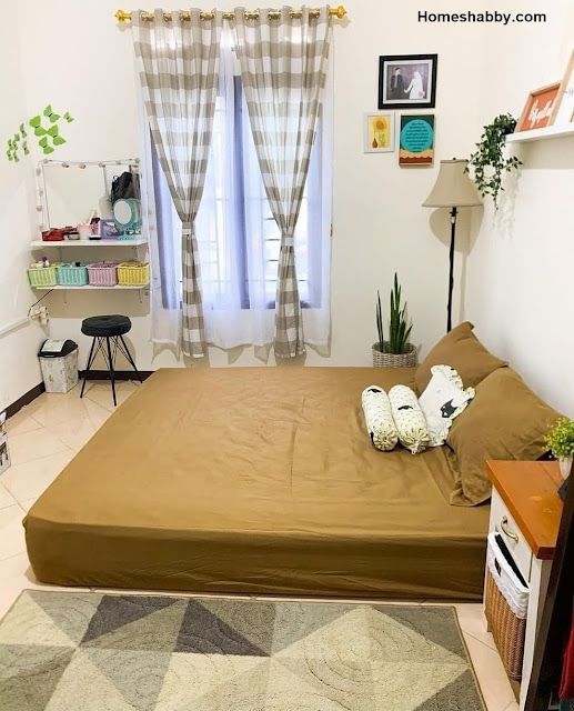 a bed sitting next to a window in a room with a rug on the floor